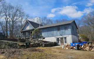 Connecticut home with an aging roof showing signs of wear and potential roofing problems